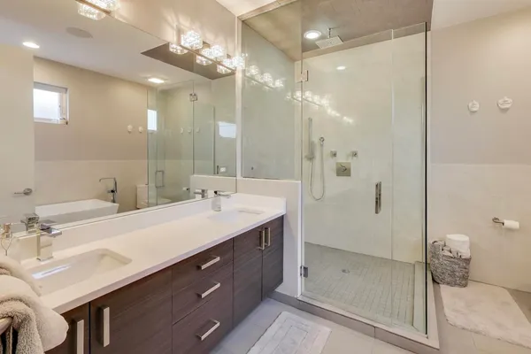 a bathroom with a double vanity sink mirror and shower