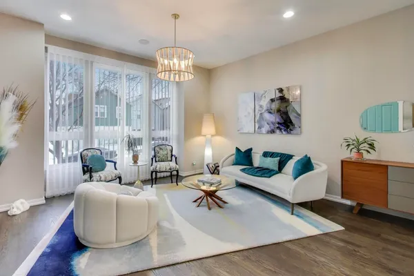 a living room with furniture chandelier and a table