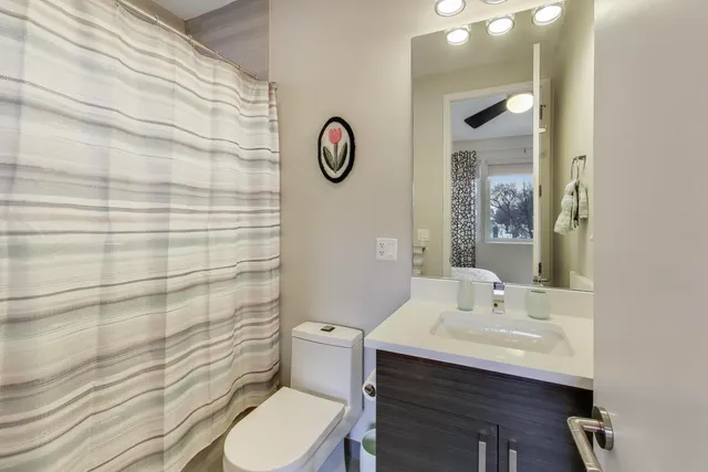 a bathroom with a sink a toilet and shower curtain