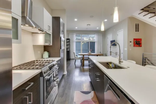 a kitchen with kitchen island granite countertop a sink stove and cabinets