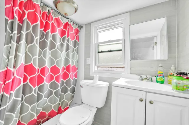 a bathroom with a sink toilet and window