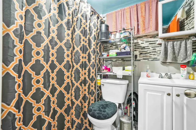 a bathroom with a sink toilet and shower curtain
