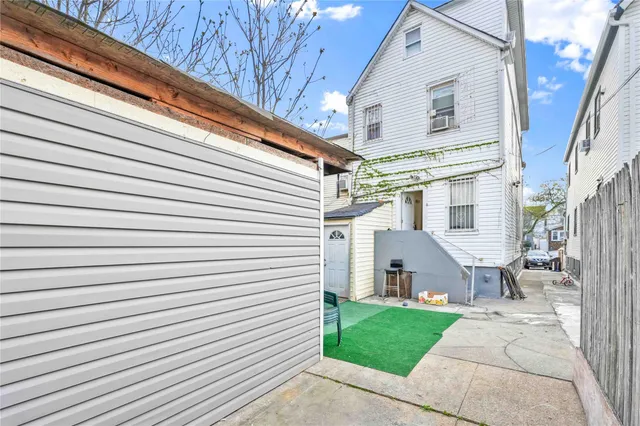 a view of a white house with a small yard and a large window