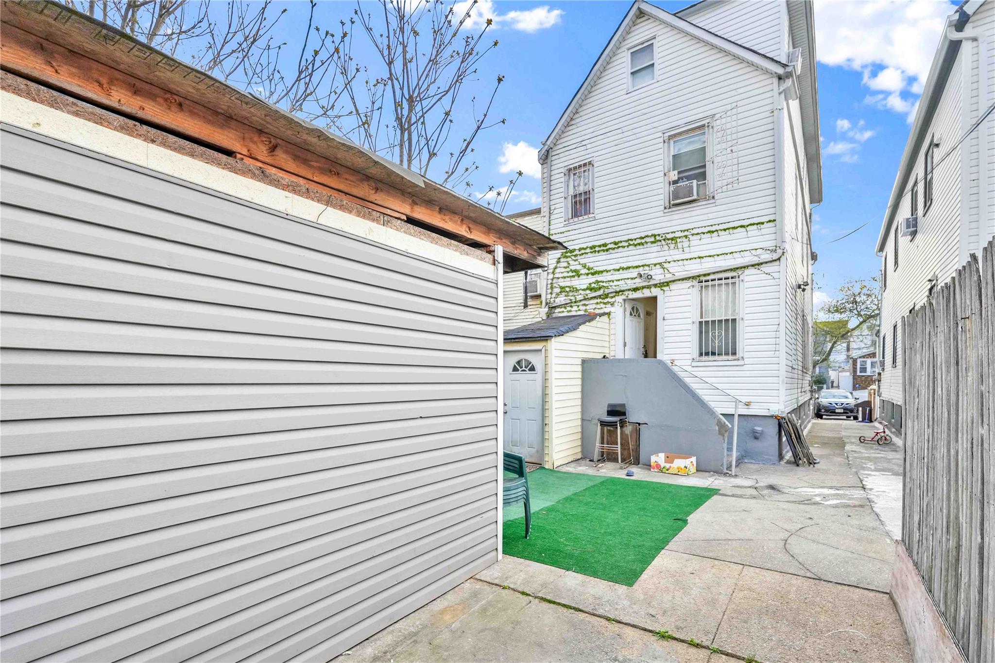 109-55 Lefferts Boulevard Queens, NY 11420 - Photo 5 of 21 a view of a white house with a small yard and a large window