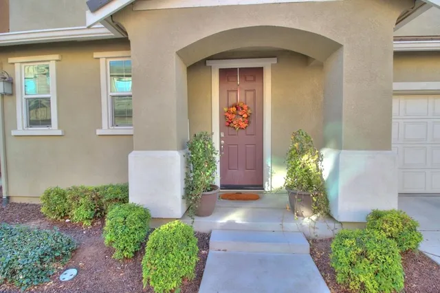 a front view of a house with lots of flowers