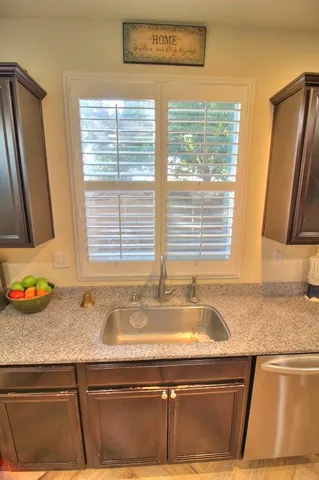 a view of kitchen with granite countertop sink and dishwasher next to a window