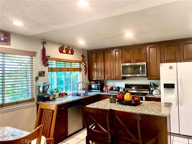 a kitchen with stainless steel appliances granite countertop a stove a sink a refrigerator a microwave oven with granite countertops and cabinets