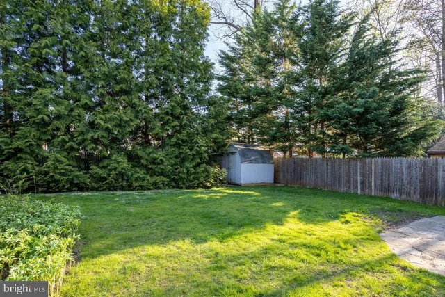 a view of backyard with table and chairs and wooden fence
