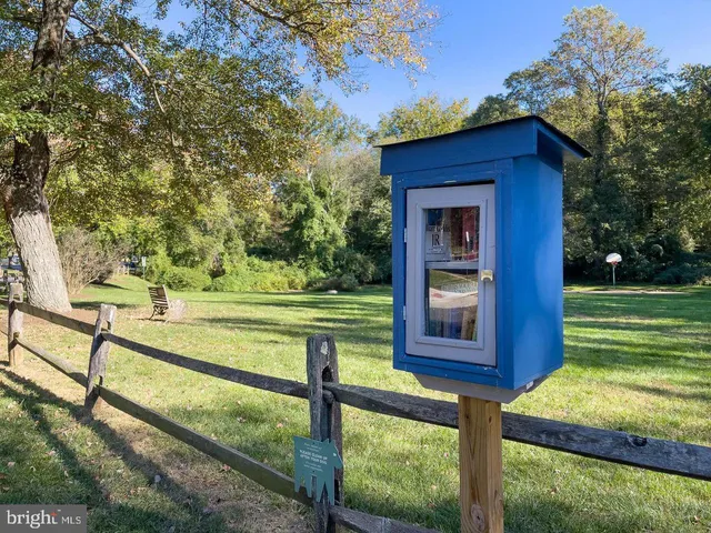 a view of a wooden house with a yard and large tree
