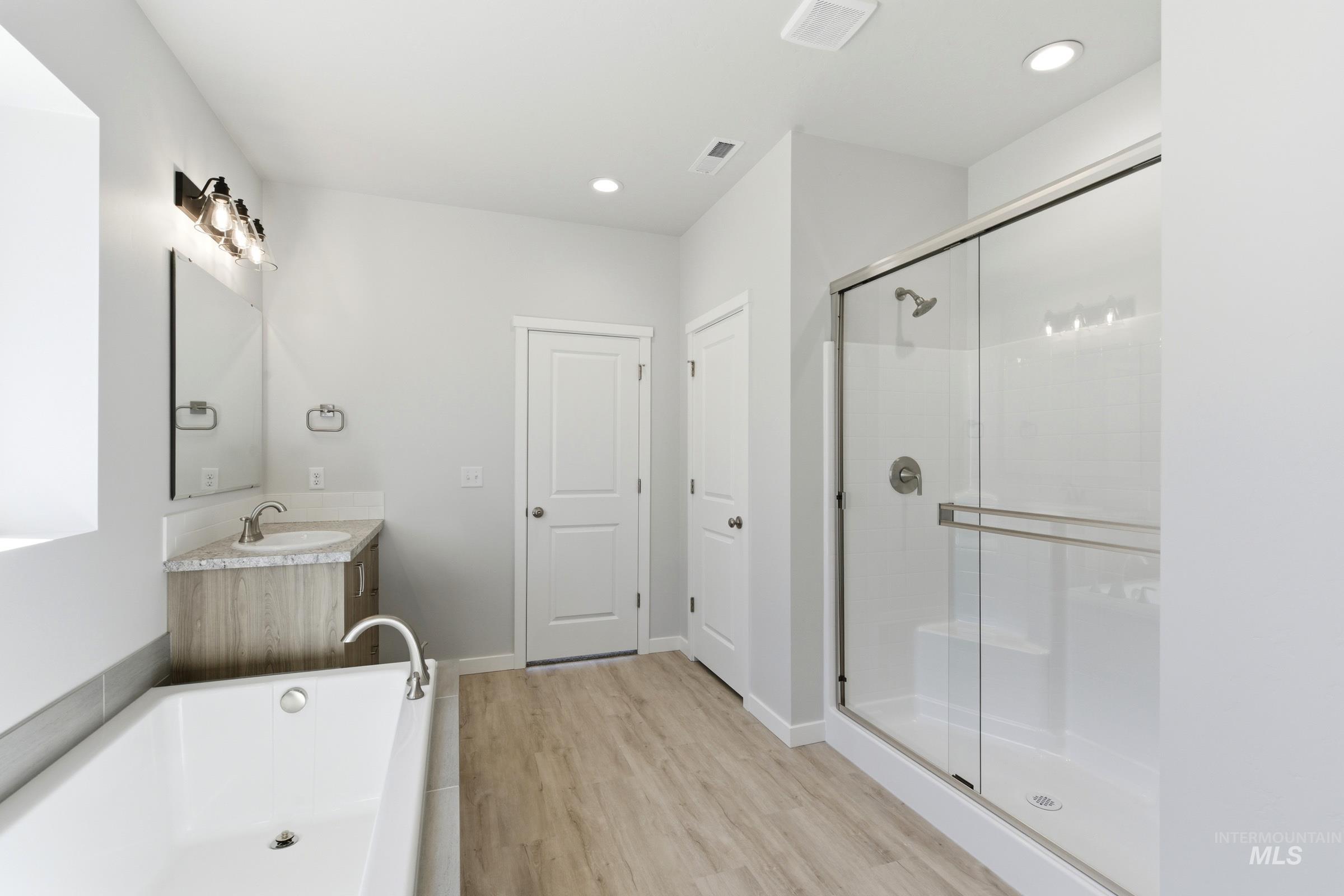 13663 Redway Court Caldwell, ID 83607 - Photo 32 of 32 Full bathroom featuring a large soaking tub, glass-enclosed shower, wood-finish vanity with a single basin sink, and recessed lighting