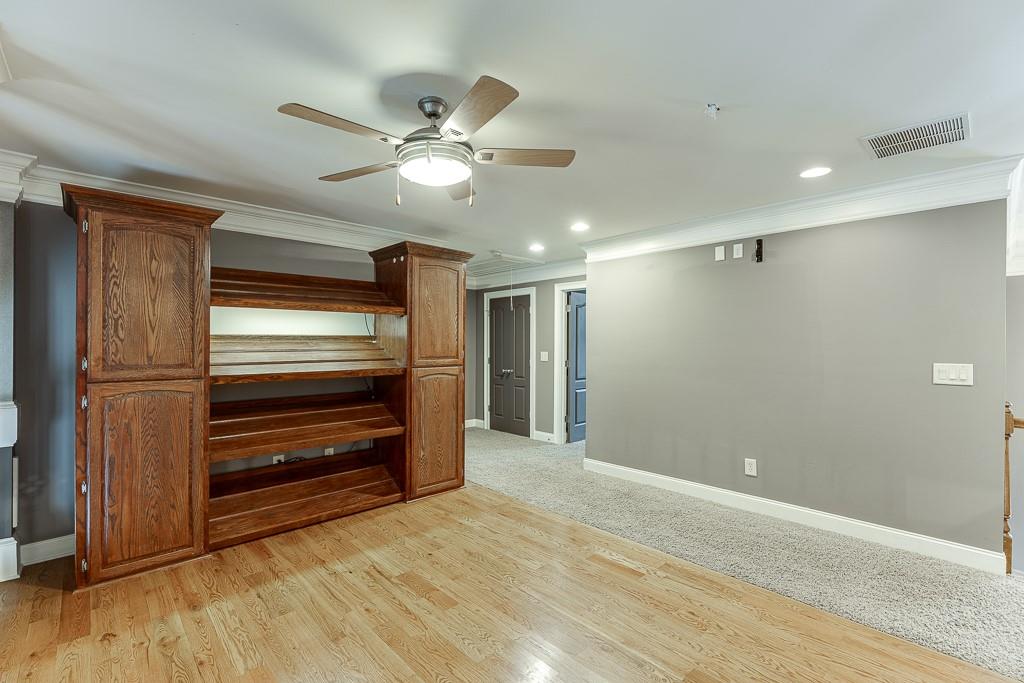 940 Chateau Forest Road Hoschton, GA 30548 - Photo 44 of 87 a view of an empty room with wooden floor and a ceiling fan