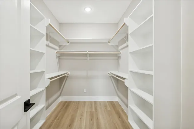 a view of walk in closet with empty racks