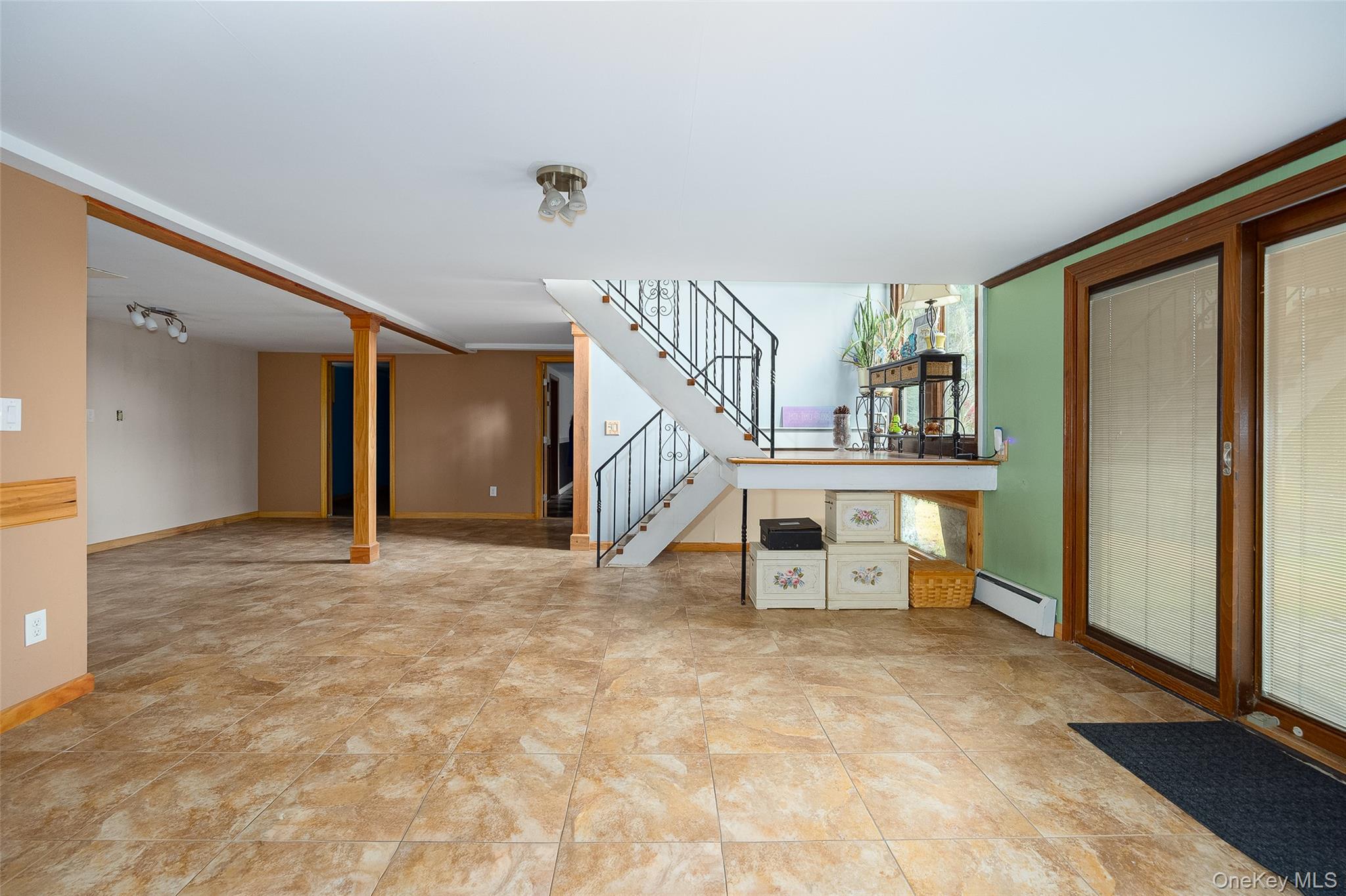 21 North Gate Road Carmel, NY 10512 - Photo 27 of 31 Unfurnished living room featuring a baseboard radiator and stairway