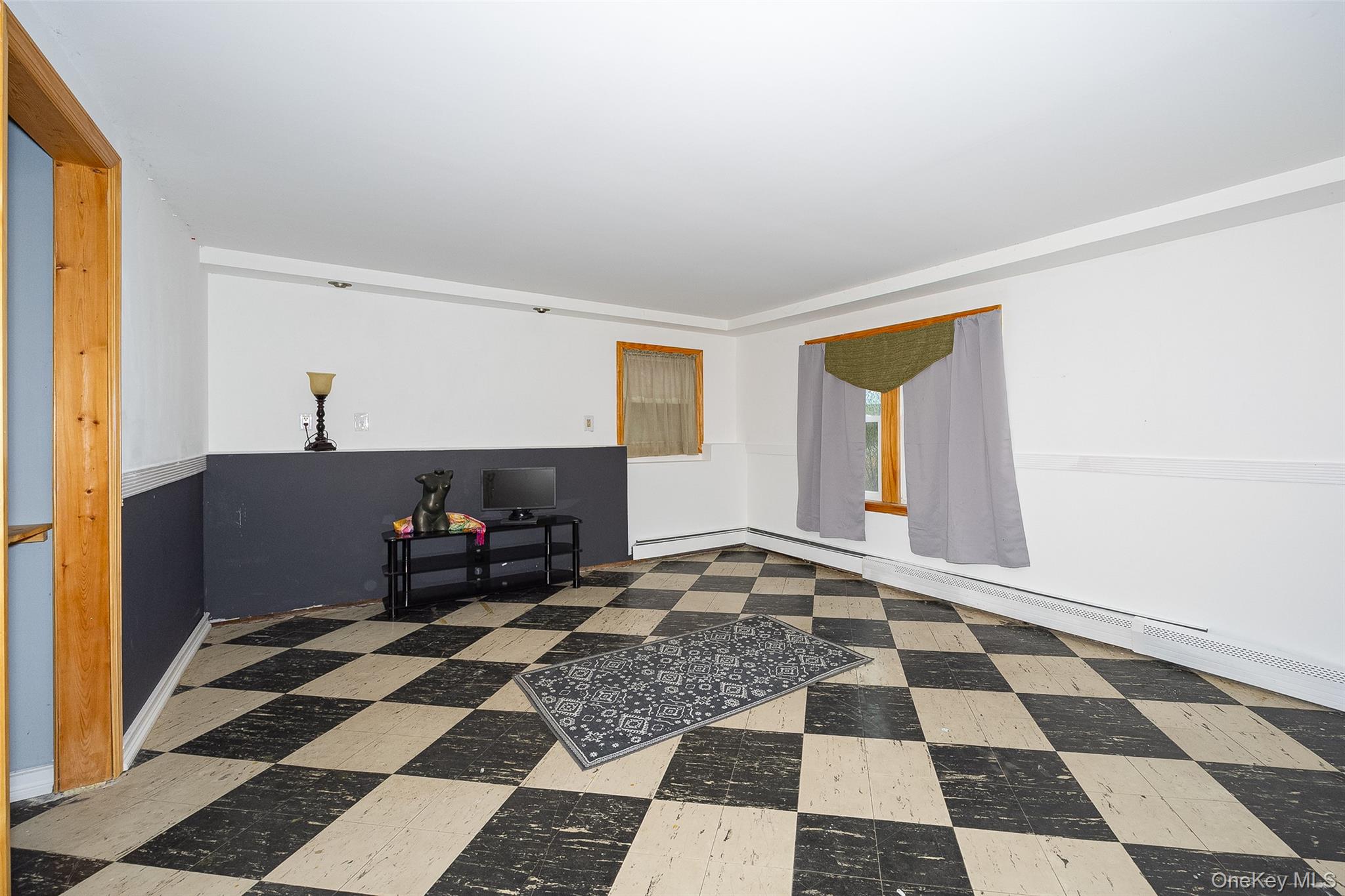 21 North Gate Road Carmel, NY 10512 - Photo 30 of 31 a room with a black white checkered floor with a gaming machine and a rug