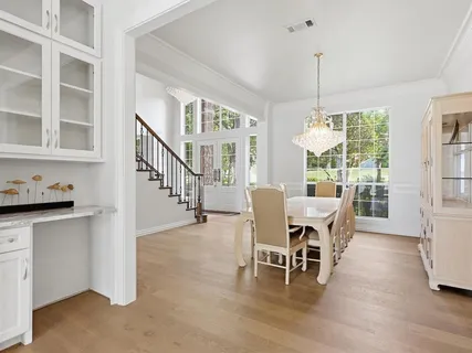 a view of an empty room with wooden floor fireplace and a window