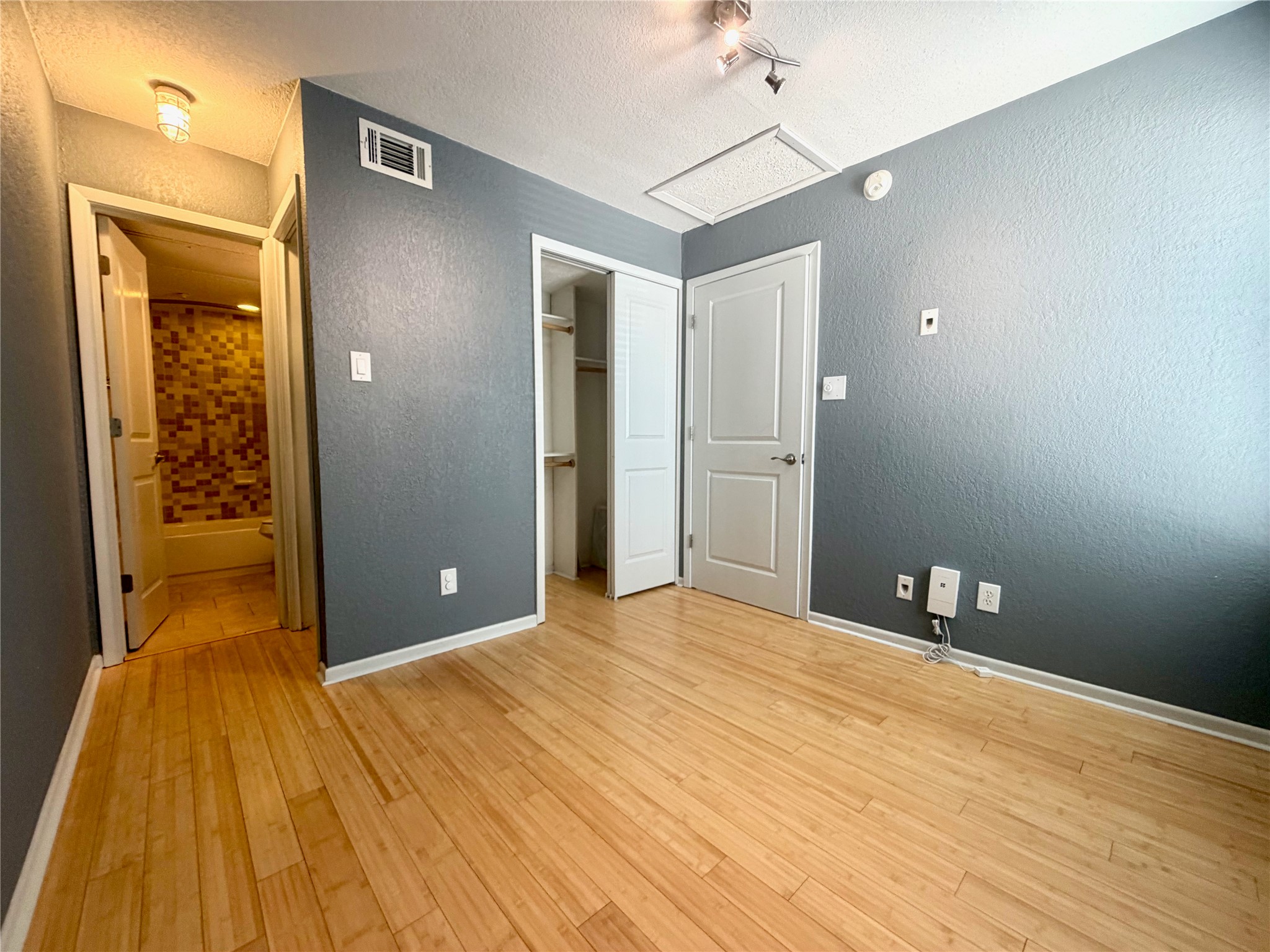 3204 Manchaca Road, Unit 302 Austin, TX 78704 - Photo 9 of 20 Warm wood flooring pairs with clean walls and convenient closet space in this versatile bedroom.