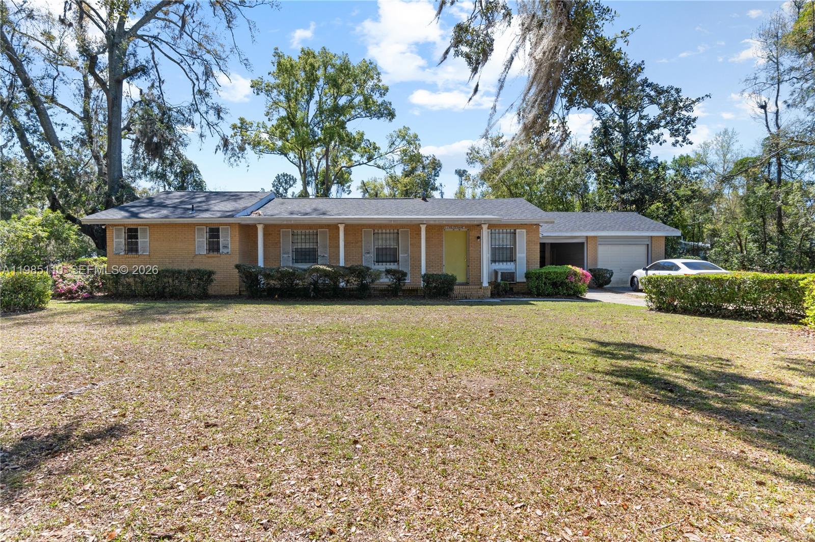 115 Southwest Lee Avenue Madison, FL 32340 - Photo 1 of 17 a front view of a house with a garden and trees