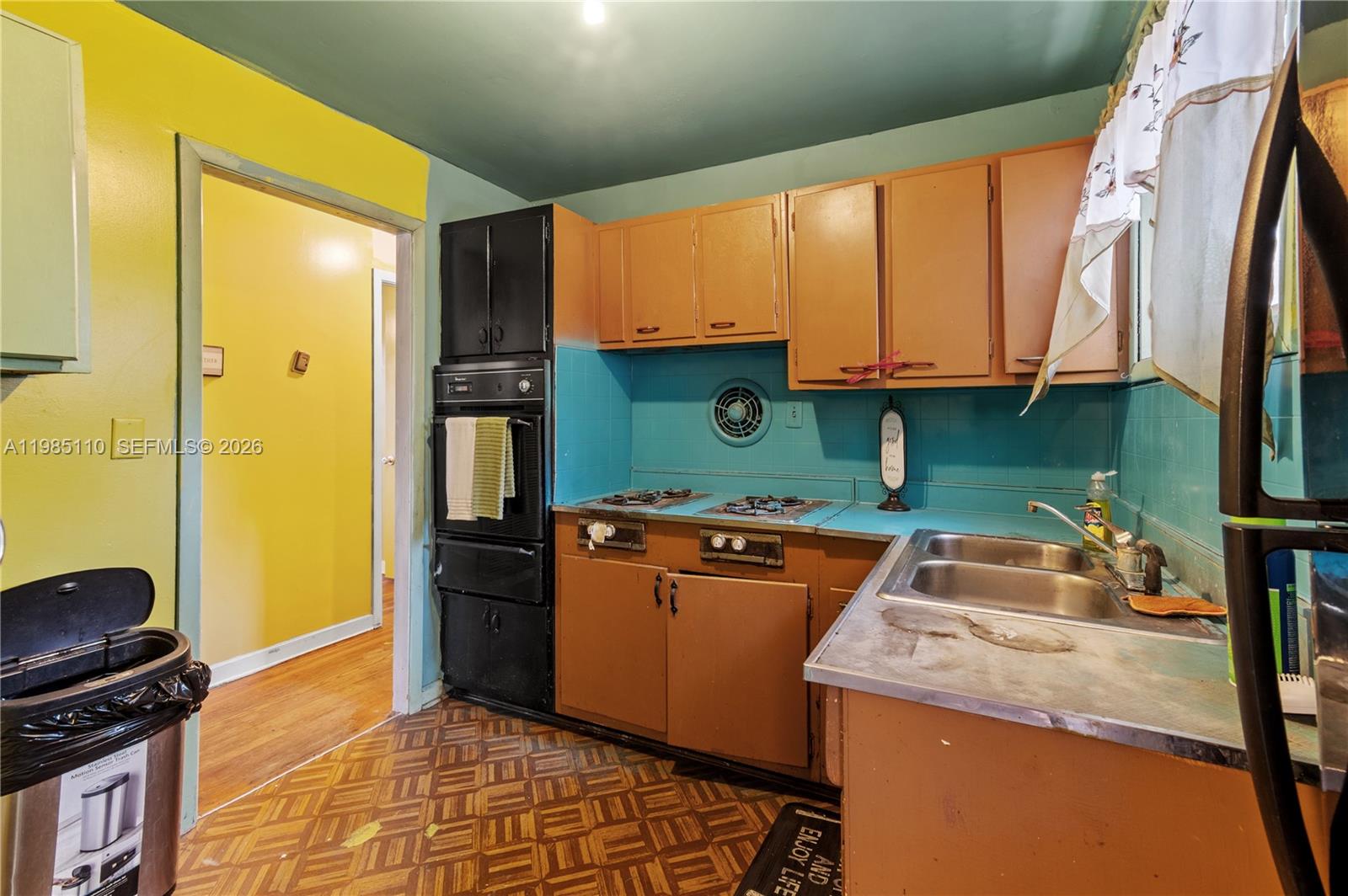 115 Southwest Lee Avenue Madison, FL 32340 - Photo 10 of 17 a kitchen with a sink a stove top oven a refrigerator and a view of living room