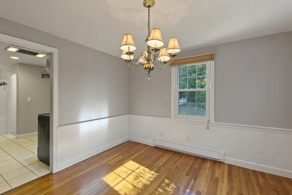a view of a room with wooden floor fan and windows