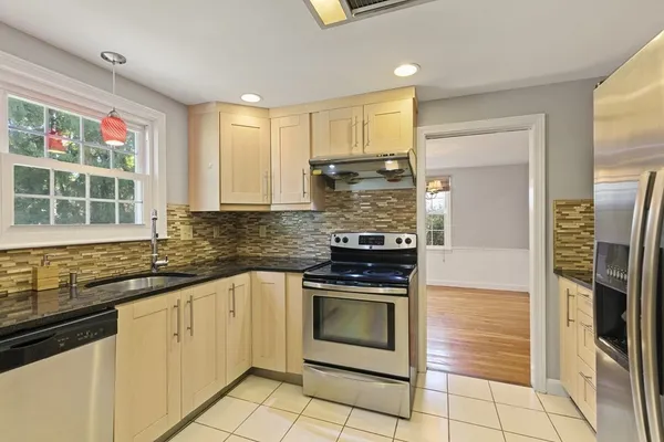 a kitchen with stainless steel appliances granite countertop a stove a sink and a refrigerator