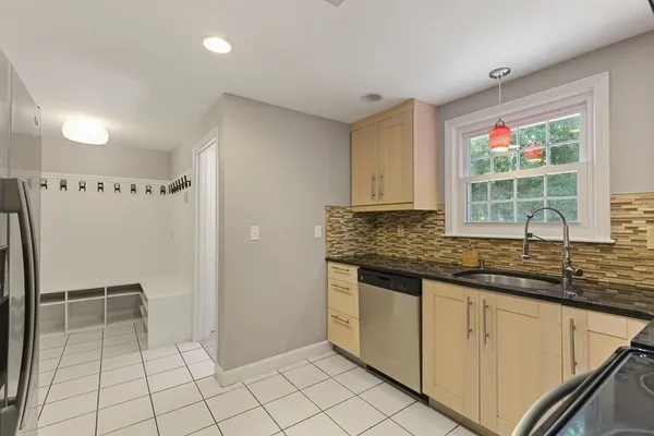 a kitchen with granite countertop a sink window and cabinets