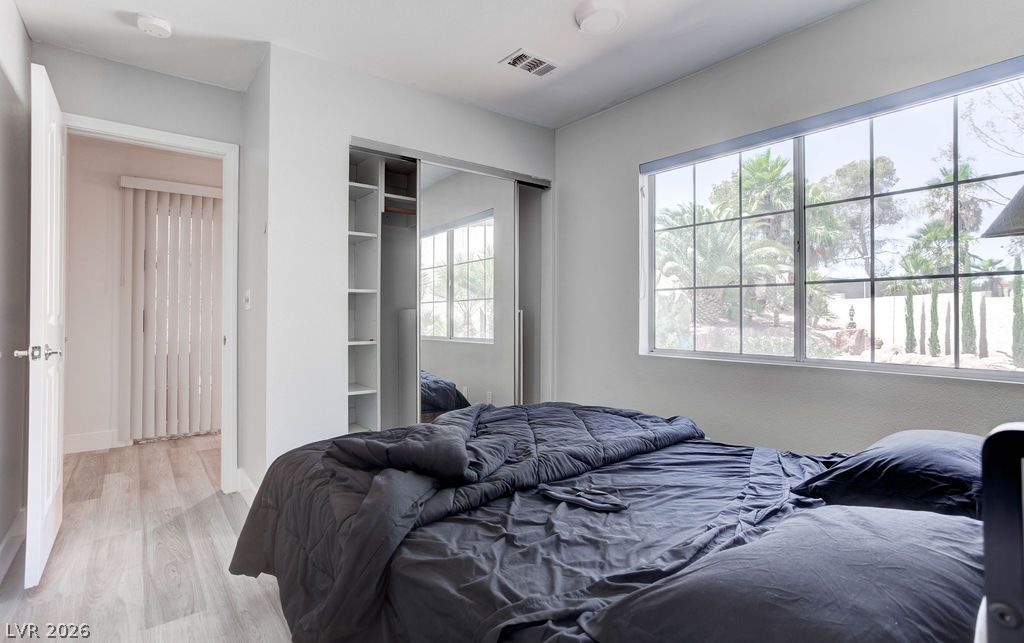 1 Rising Sun Court Henderson, NV 89074 - Photo 17 of 47 A tranquil bedroom with a spacious window offers verdant outdoor views and ample natural illumination.