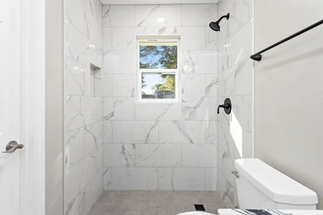 a bathroom with a toilet and a shower