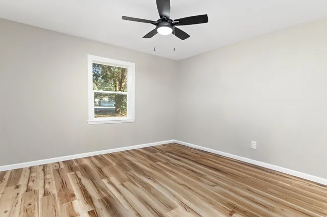 a view of room with hardwood floor and a ceiling fan