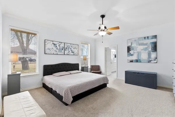 a bedroom with a large bed a chandelier and a window