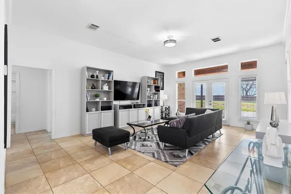 a living room with furniture a flat screen tv and a window