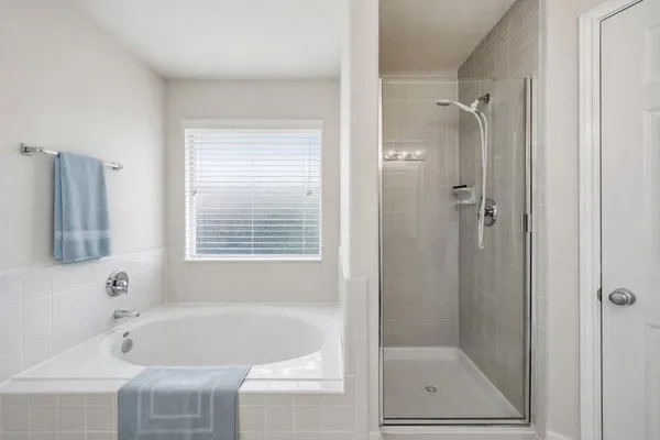 a white bath tub sitting next to a shower