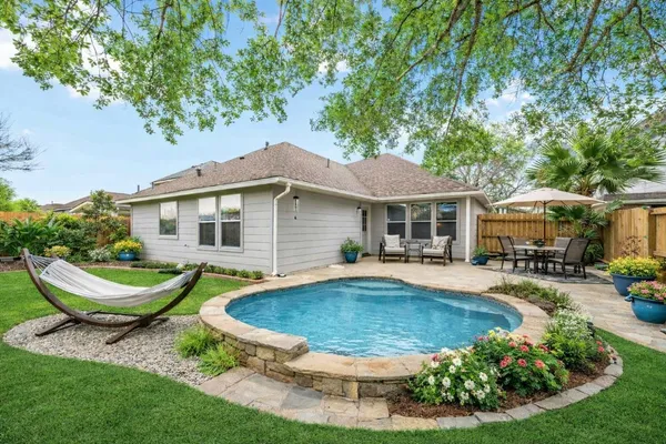 a view of a house with backyard sitting area and swimming pool