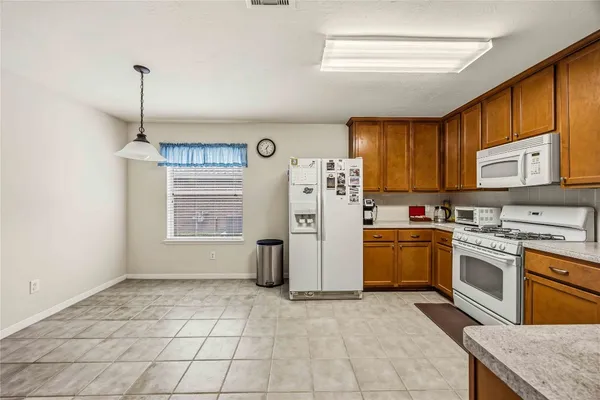 a kitchen with a stove a refrigerator and cabinets
