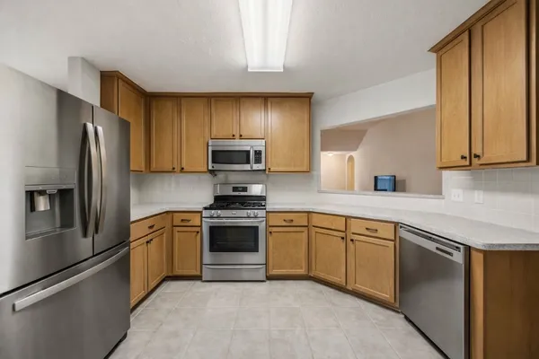 a kitchen with stainless steel appliances granite countertop a refrigerator stove a sink and dishwasher