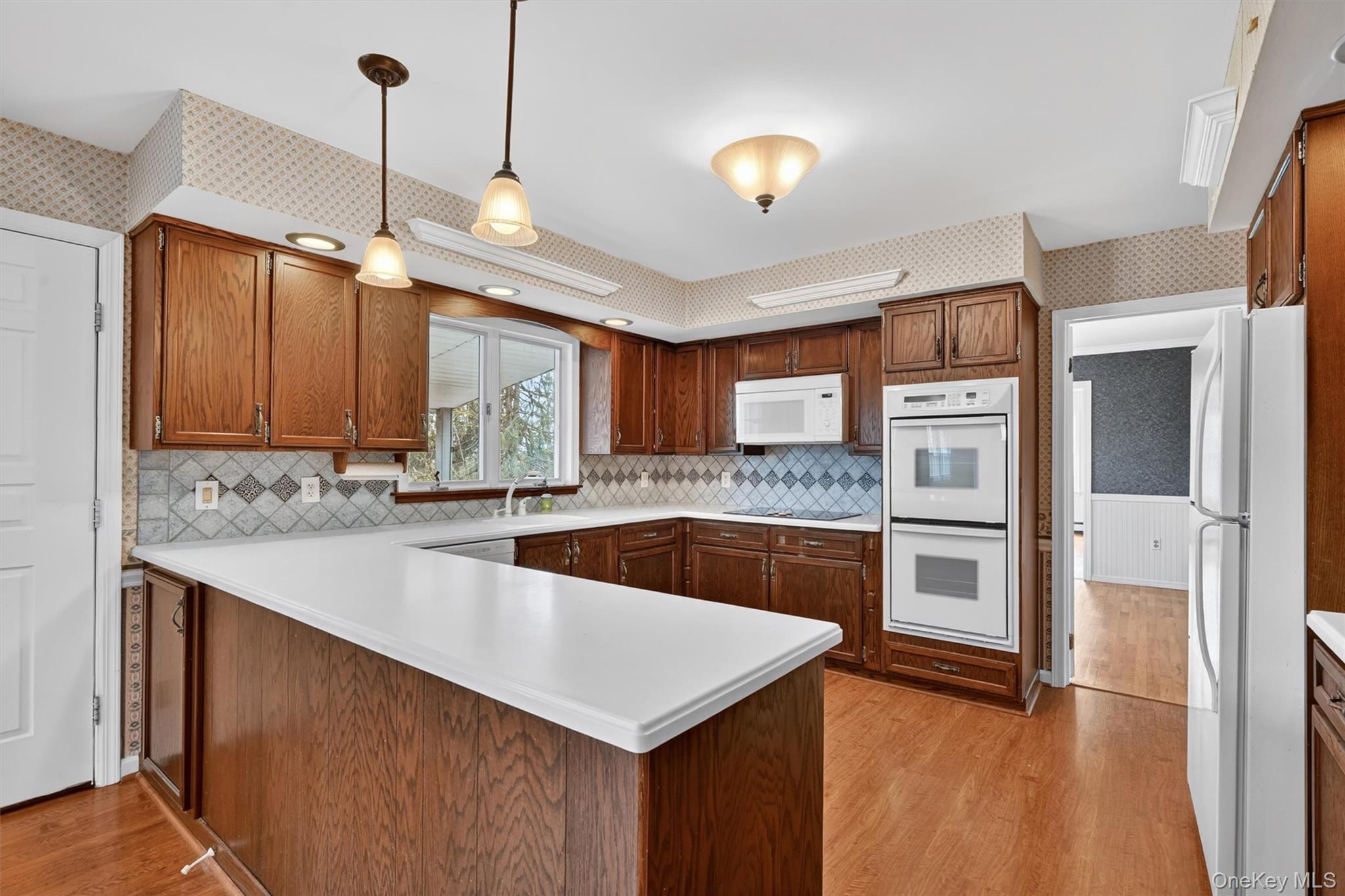 47 Still Road Westtown, NY 10998 - Photo 16 of 49 The kitchen features extensive wood cabinetry, white countertops, and a tiled backsplash.