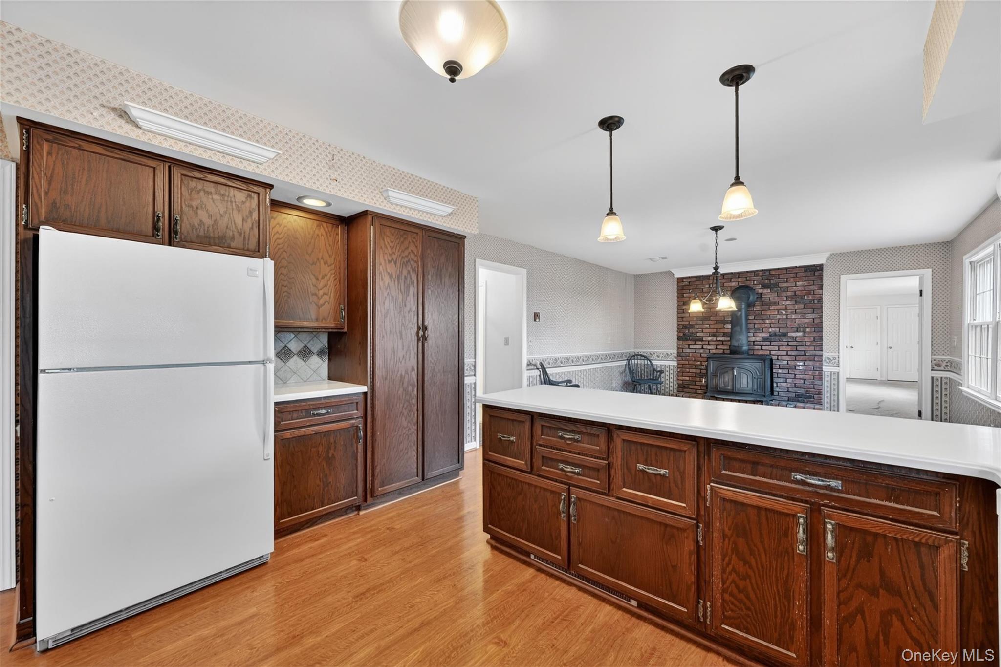 47 Still Road Westtown, NY 10998 - Photo 18 of 49 Kitchen with wood cabinetry, a white refrigerator, and an expansive island featuring a white countertop.