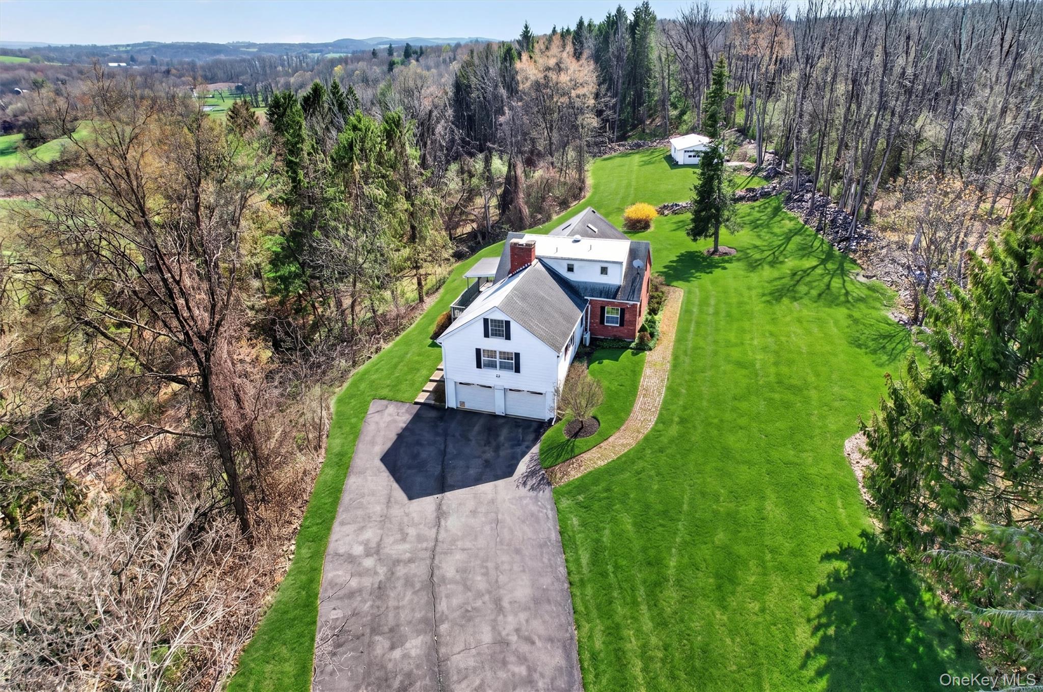 47 Still Road Westtown, NY 10998 - Photo 2 of 49 The property features a white and brick exterior with black shutters and a two-car garage.