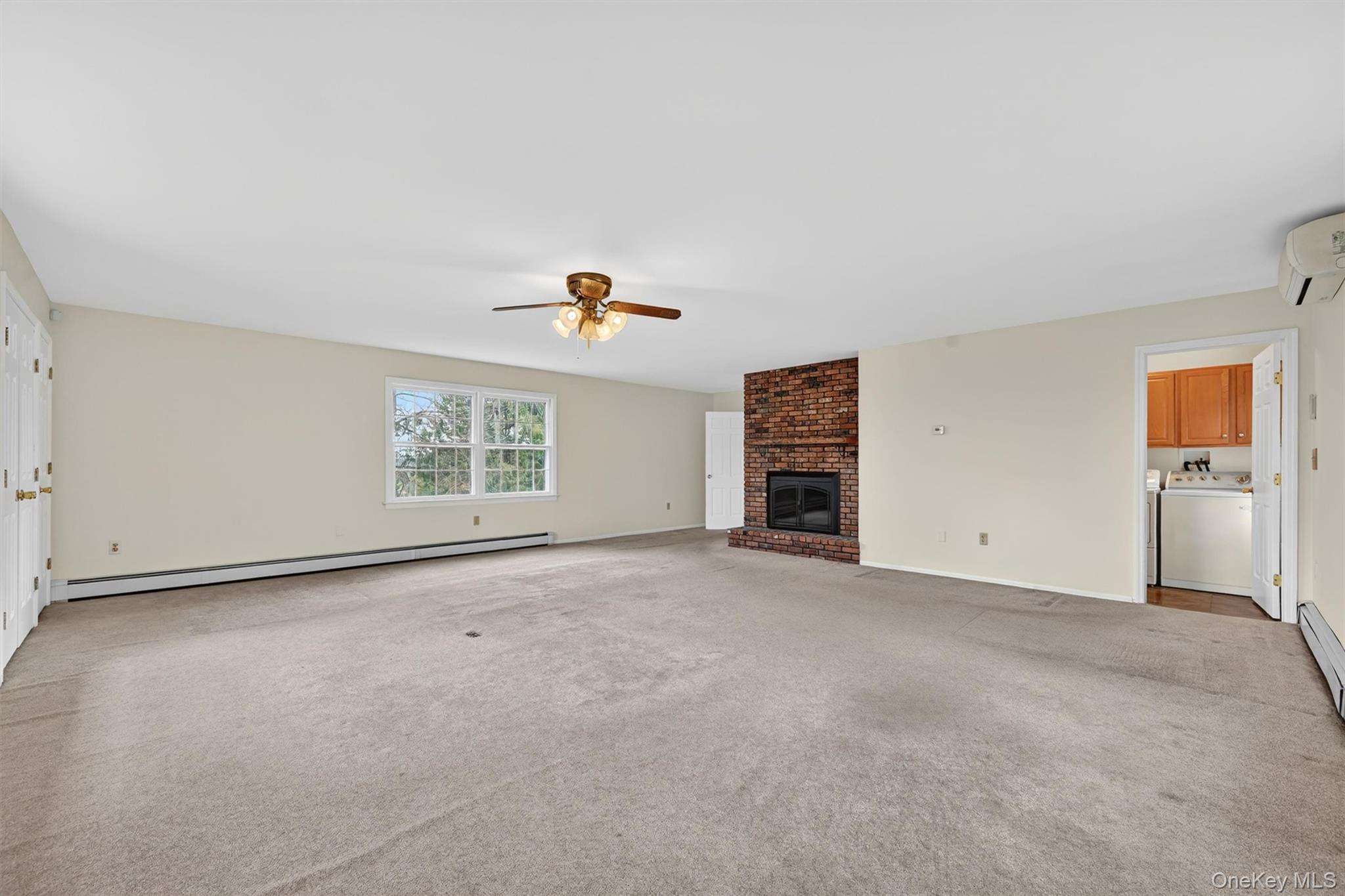 47 Still Road Westtown, NY 10998 - Photo 22 of 49 Family room - actual view. It is a spacious living area featuring neutral-toned walls, carpeting, and a brick fireplace.