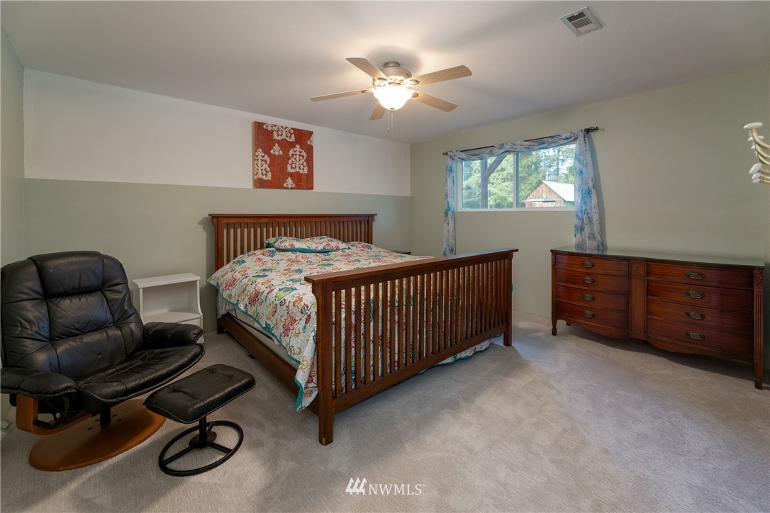 12020 Moen Road Granite Falls, WA 98252 - Photo 16 of 27 a bedroom with a bed and a chandelier