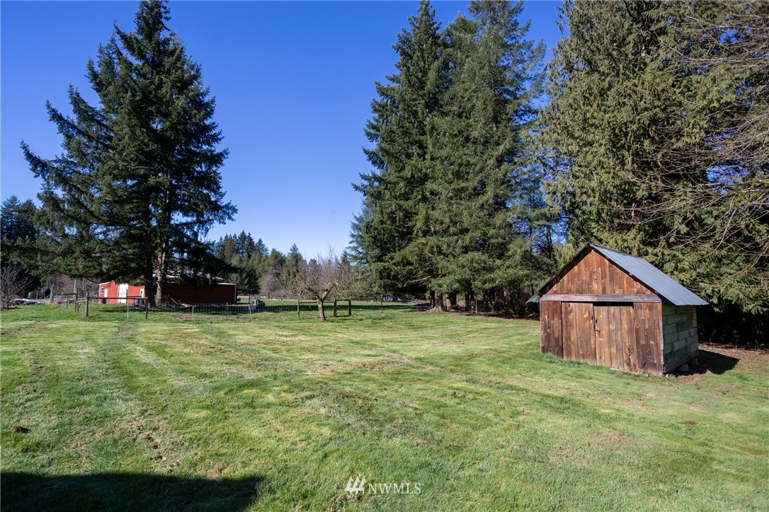 12020 Moen Road Granite Falls, WA 98252 - Photo 21 of 27 a view of a wooden house with a big yard and large trees