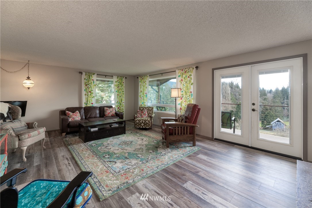 12020 Moen Road Granite Falls, WA 98252 - Photo 6 of 27 a living room with furniture and a floor to ceiling window