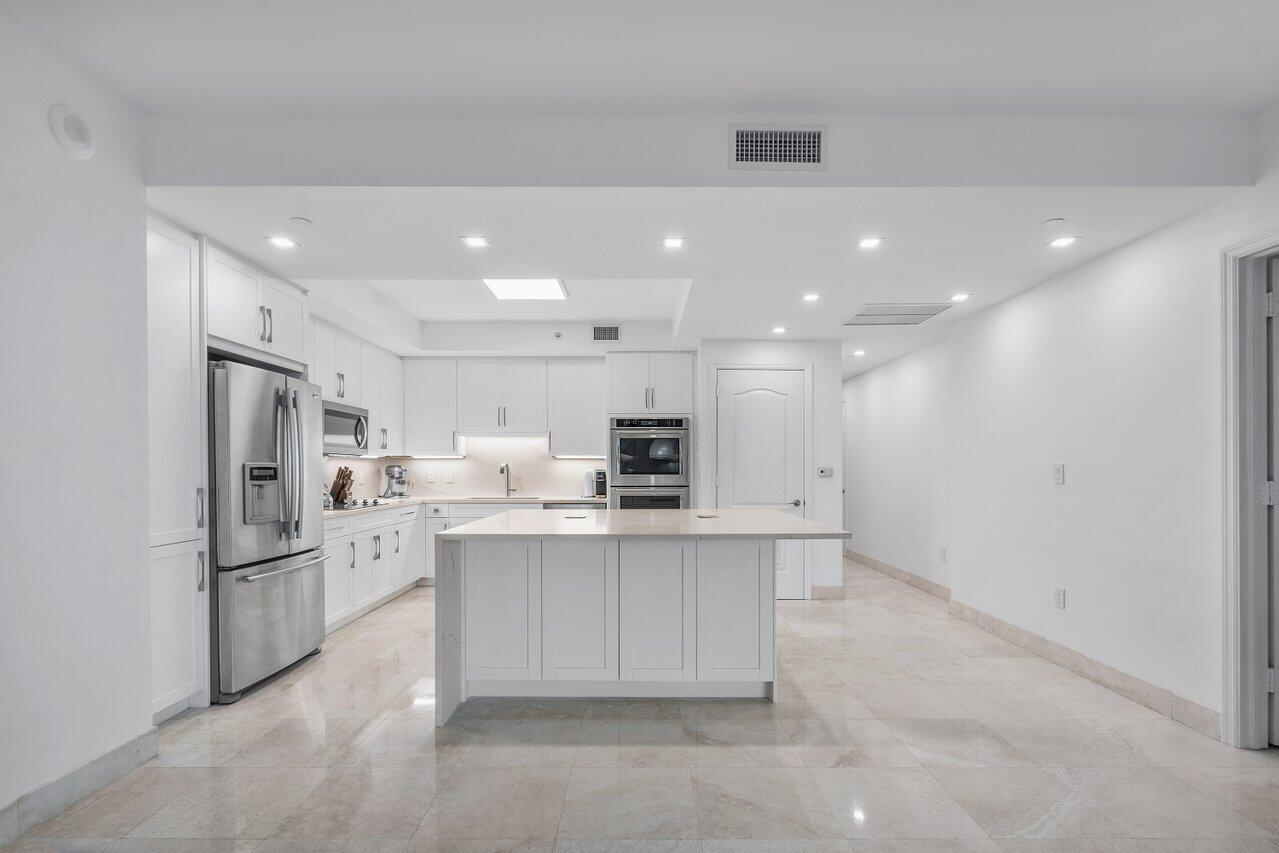 550 Southeast Mizner Boulevard, Unit B706 Boca Raton, FL 33432 - Photo 9 of 64 a kitchen with stainless steel appliances kitchen island sink refrigerator and cabinets