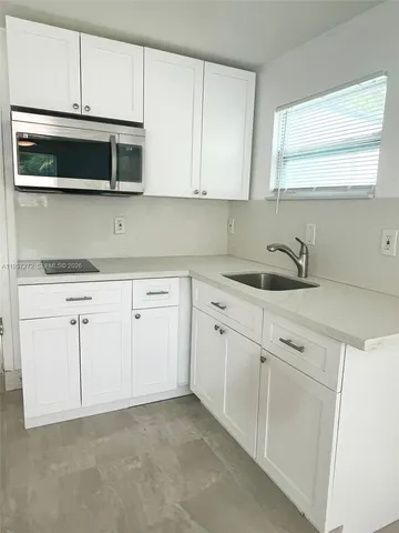 a kitchen with white cabinets stainless steel appliances and sink