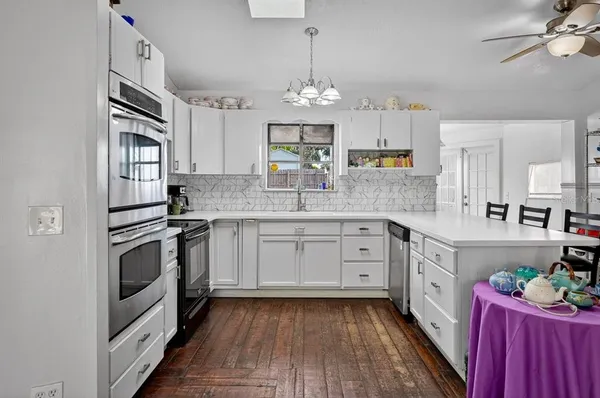 a kitchen with granite countertop stainless steel appliances sink cabinets and wooden floor