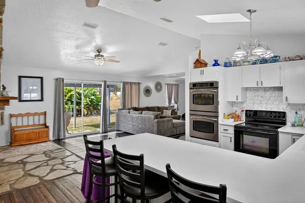 a kitchen with stainless steel appliances a dining table and chairs