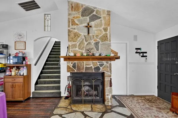 a view of an entryway with wooden floor and a fireplace