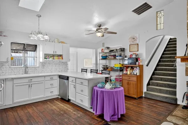 a kitchen with wooden floors and white cabinets