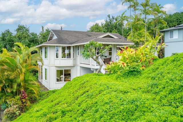a backyard of a house with table and chairs under an umbrella
