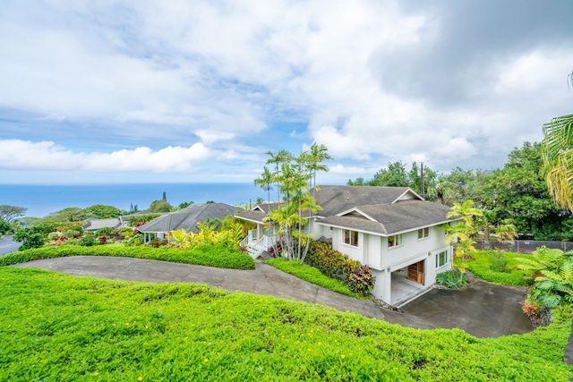 a aerial view of a house with a big yard plants and large trees