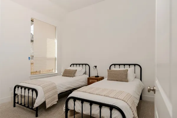 a bedroom with two beds and a window